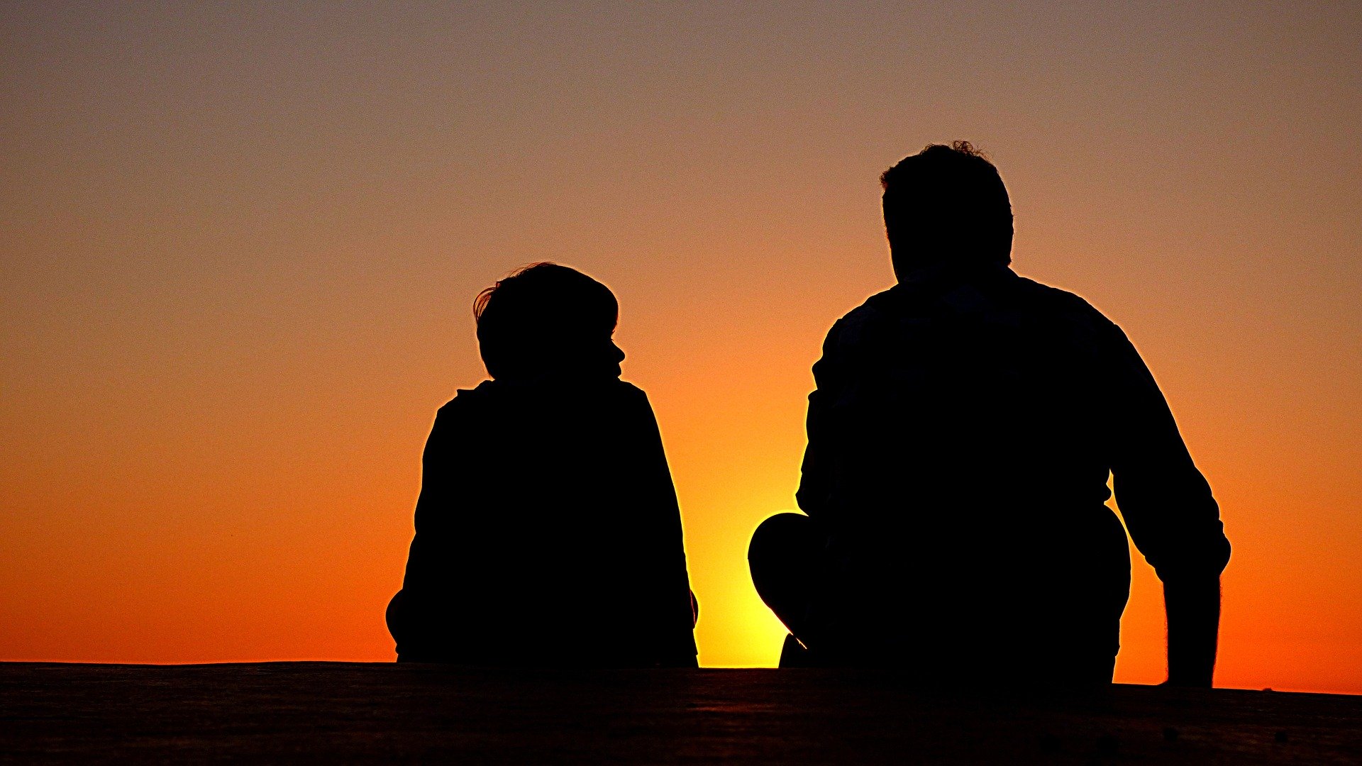 Silhouetten von Vater und Sohn im Gespräch